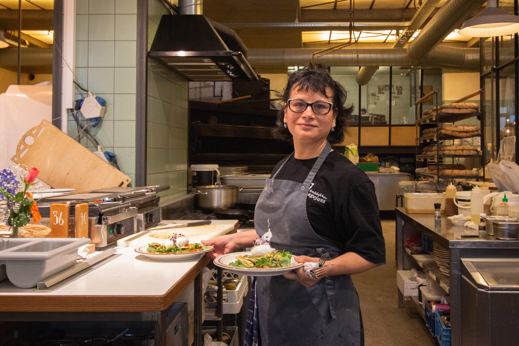 Medewerker met een vers opgemaakt bord in de keuken
