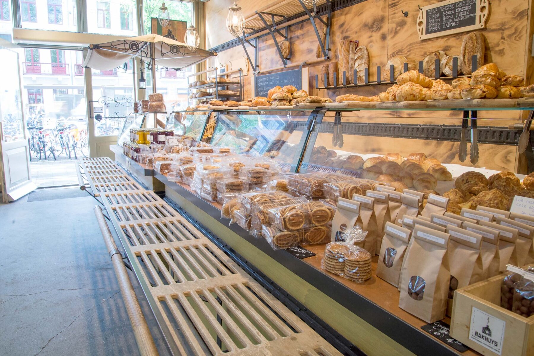 De lange toonbank vol brood en zakken granola